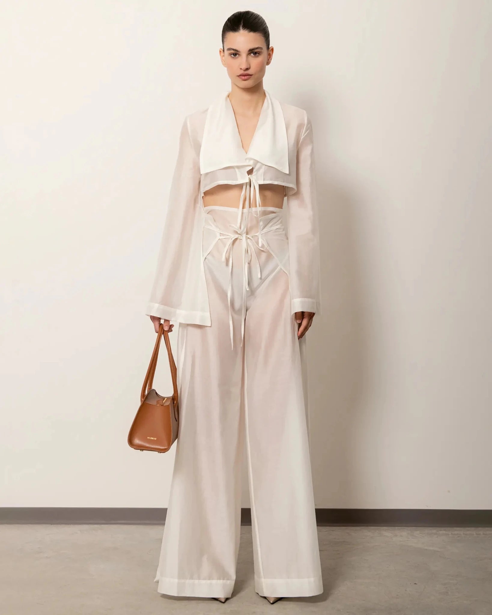 Modella con Bellucci MADBAG in pelle liscia caramello, vista laterale con look elegante