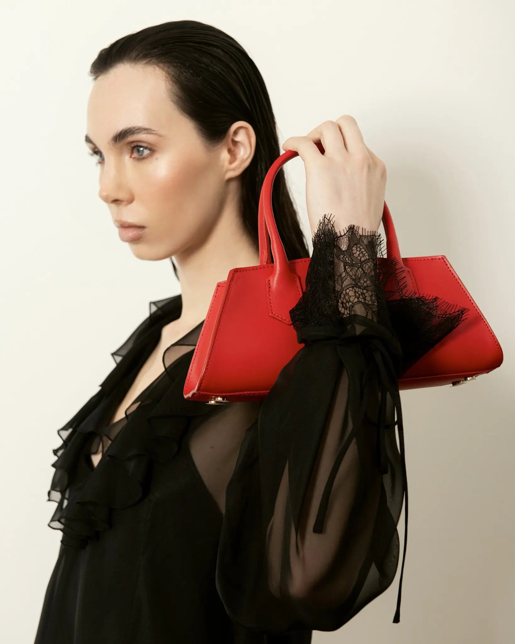 MADBAG Small Bassotto red leather handbag held by model side profile