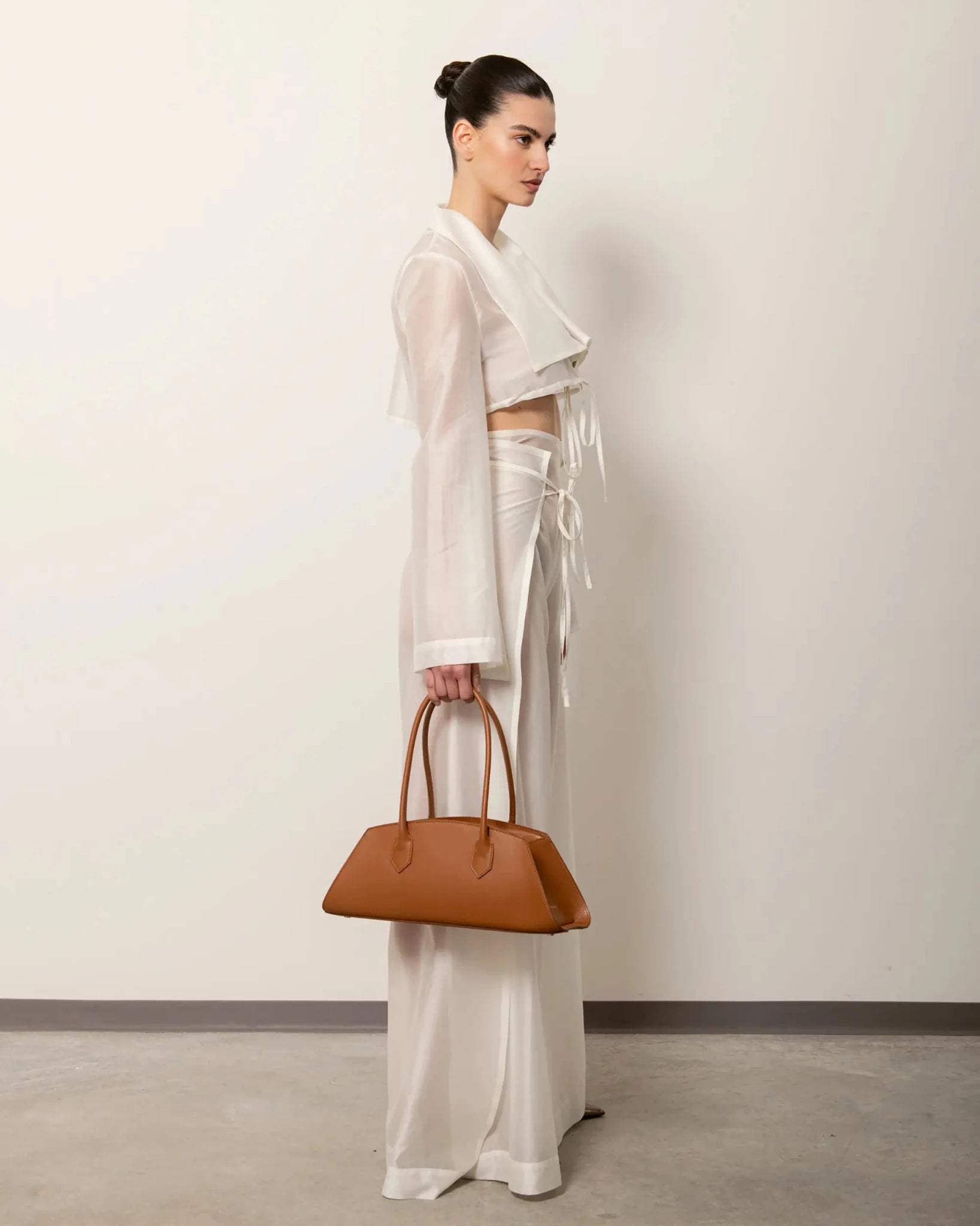 Modella con Bellucci in pelle color caramello, outfit elegante completo total look chiaro