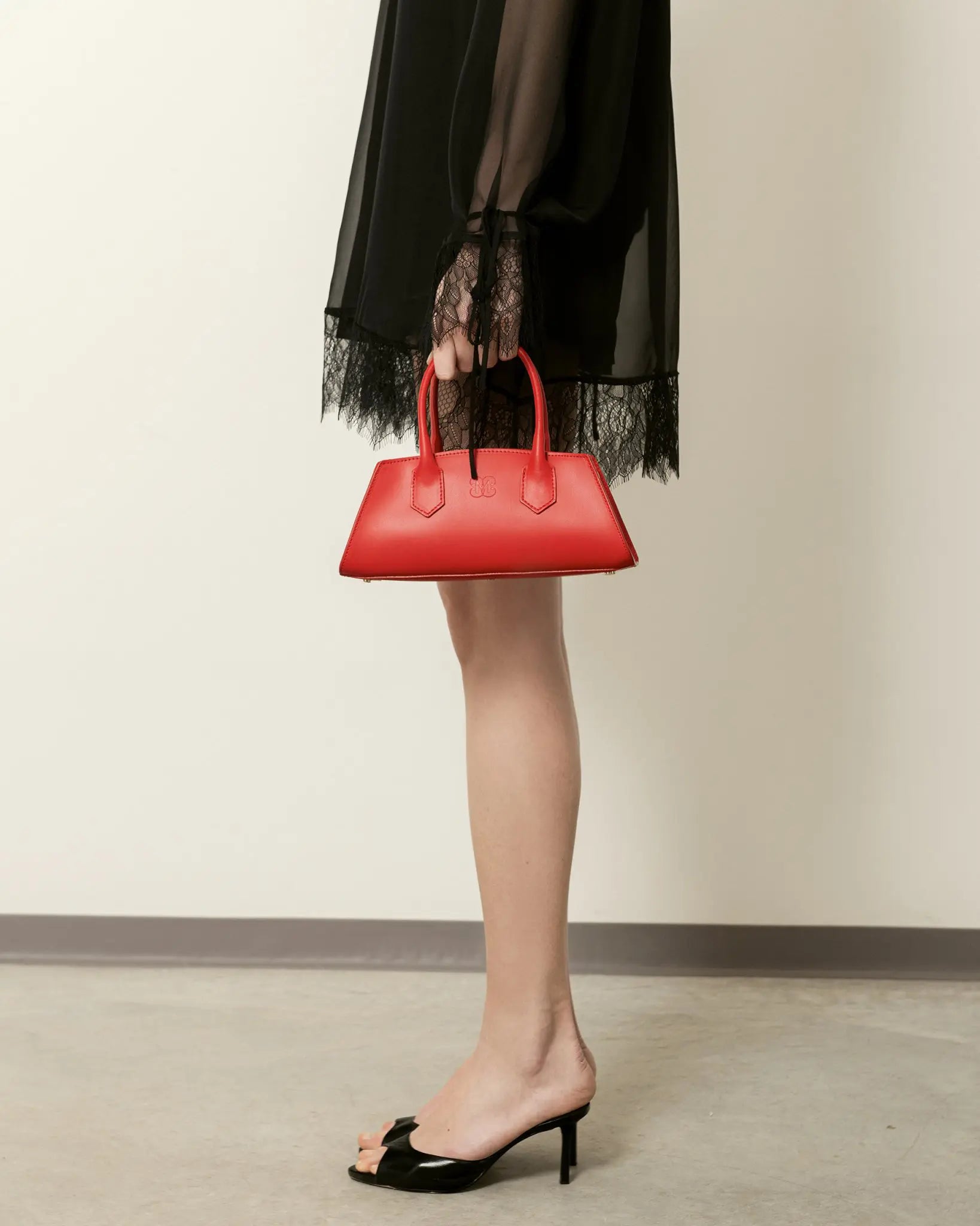 MADBAG Small Bassotto red leather handbag styled with black dress full body view