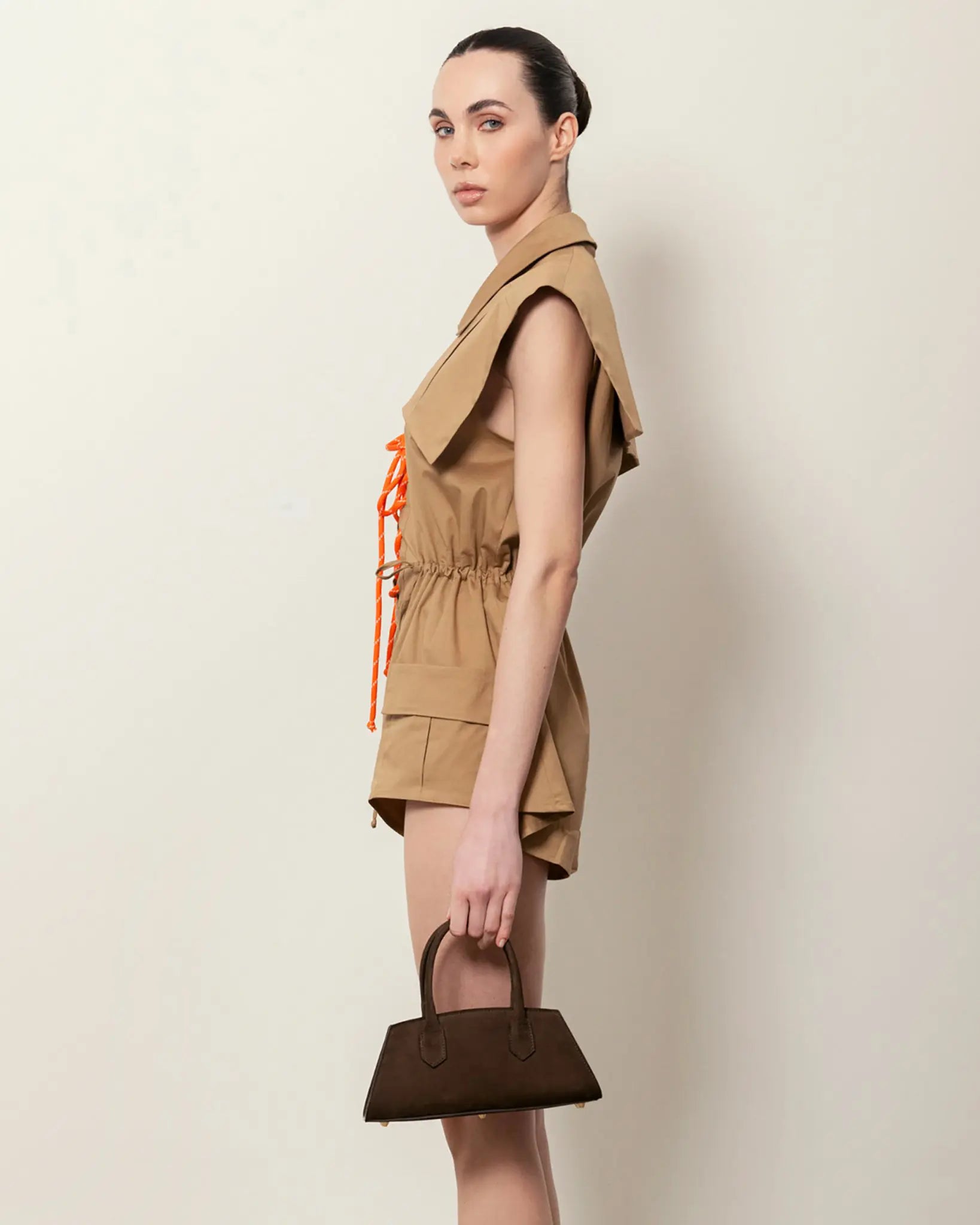  Modella di profilo con Small Bassotto in nabuk marrone, borsa a mano silhouette laterale